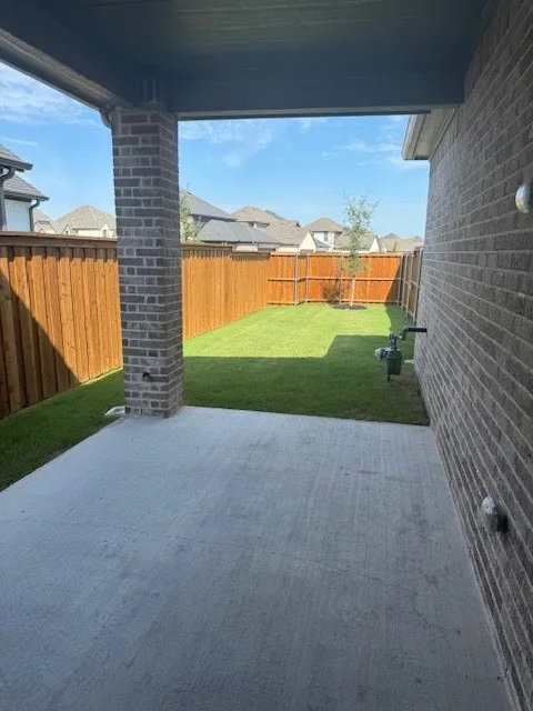 Covered concrete patio with a brick support column