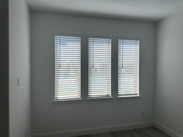 Three windows with horizontal blinds and white trim