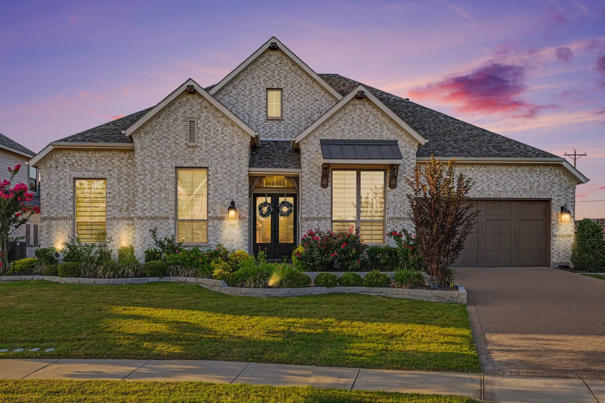Stone-finish brick exterior with multiple gables and a dark composition shingle roof