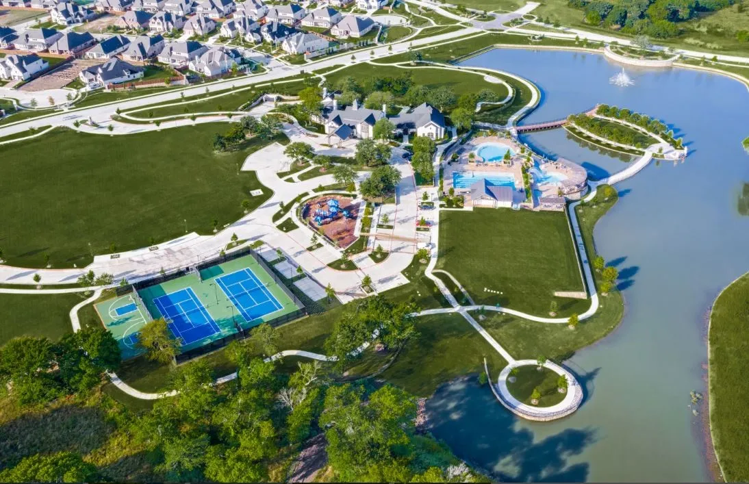 Expansive community amenities including a large body of water, multiple swimming pools, sports courts, and a playground