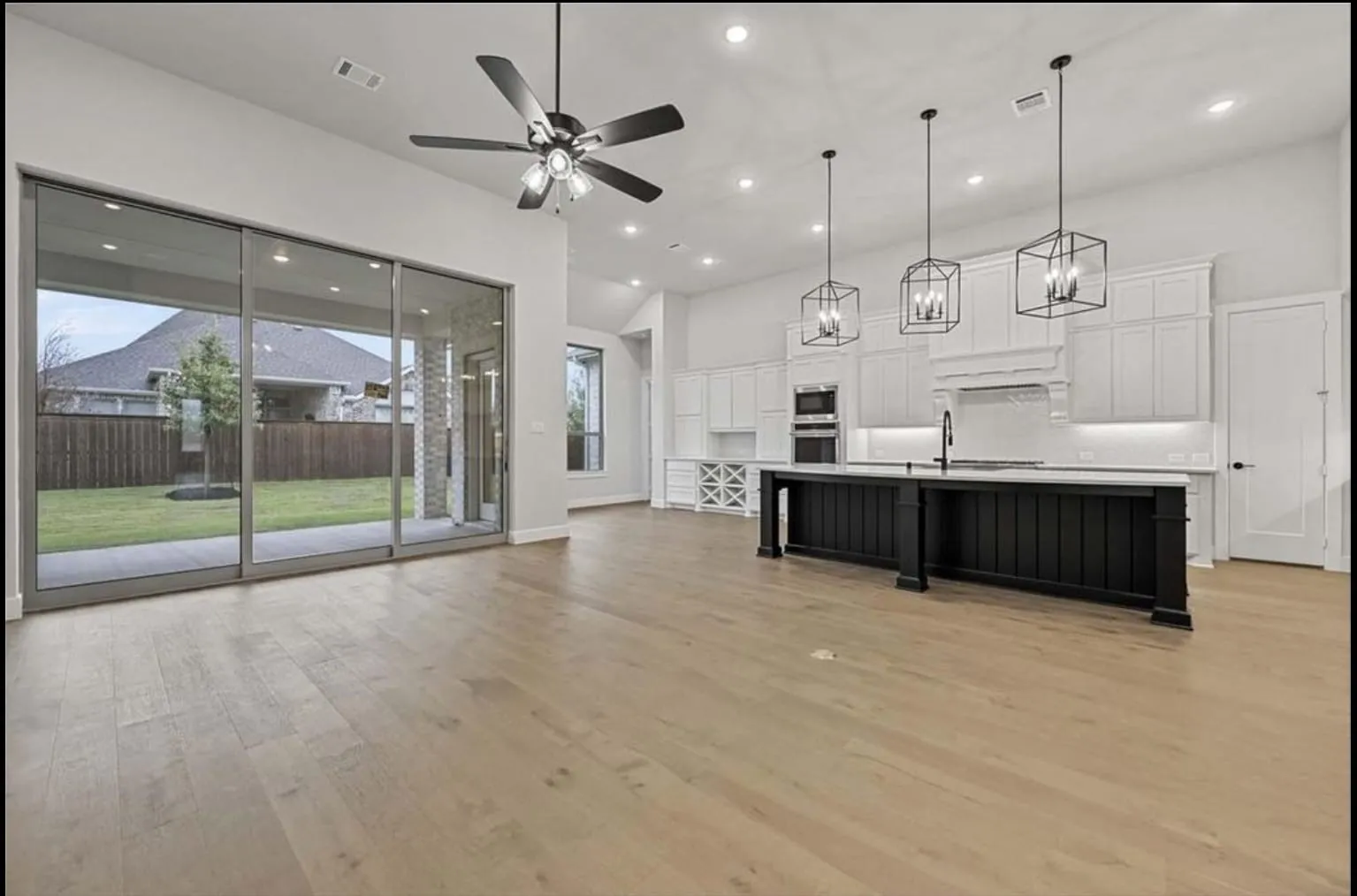 Light wood-finish flooring throughout, complemented by a contemporary ceiling fan