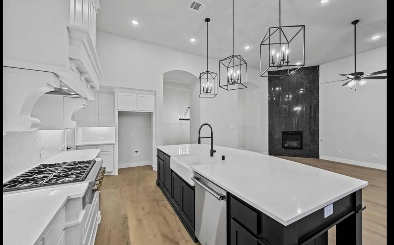 Gourmet kitchen featuring a built-in gas range, a farmhouse sink, and a large central island with seating