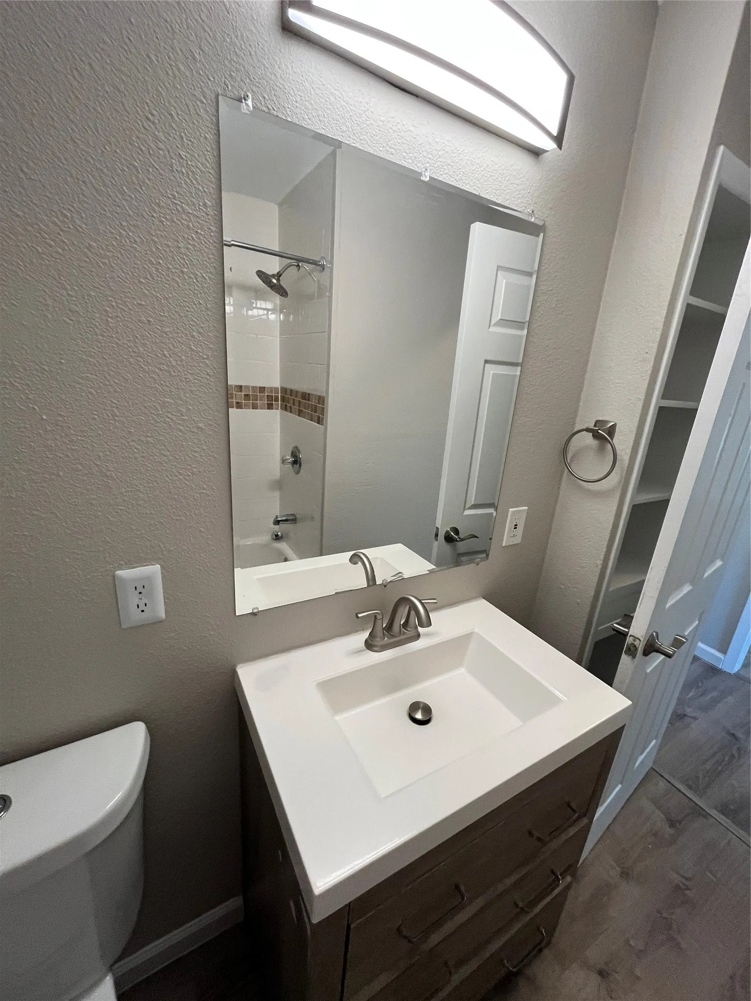Modern vanity with an integrated sink, brushed nickel faucet, and wood-finish cabinetry