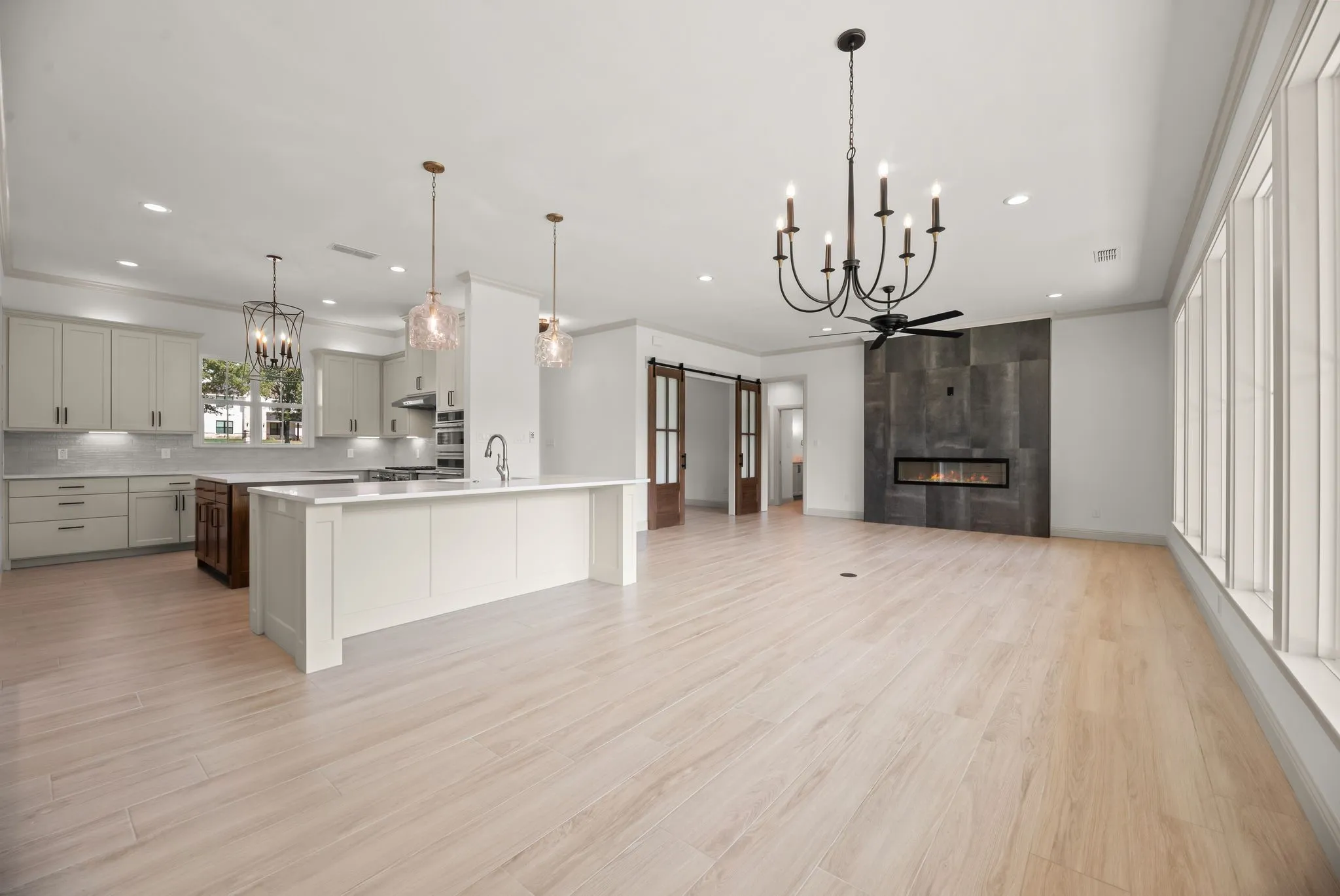 Open-concept great room connects the kitchen, dining, and living spaces for effortless entertaining in this new Corsicana lake home.