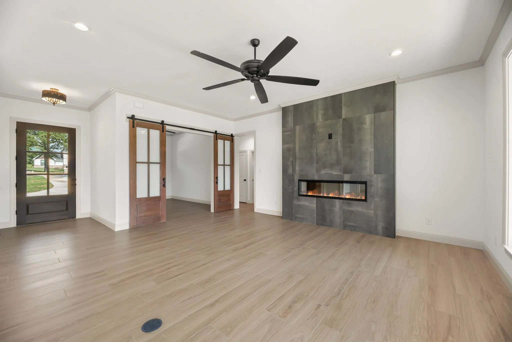 Spacious living room features a dramatic floor-to-ceiling fireplace, modern finishes, designer lighting, and an open layout ideal for lake​​‌​​​​‌​​‌‌​‌‌​​​‌‌​‌​‌​‌​​​‌​​ living.