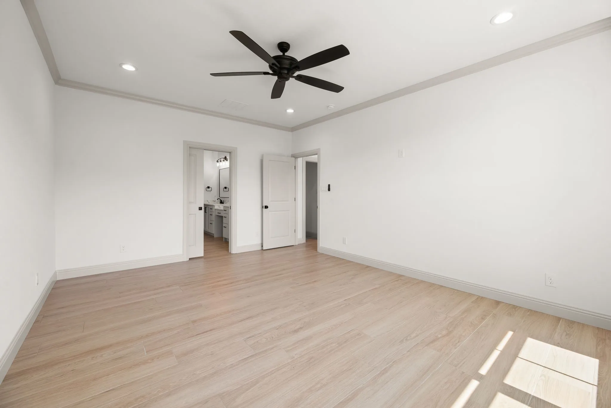 Additional primary bedroom view highlights the room's impressive size, clean architectural details, and flexible furniture placement.
