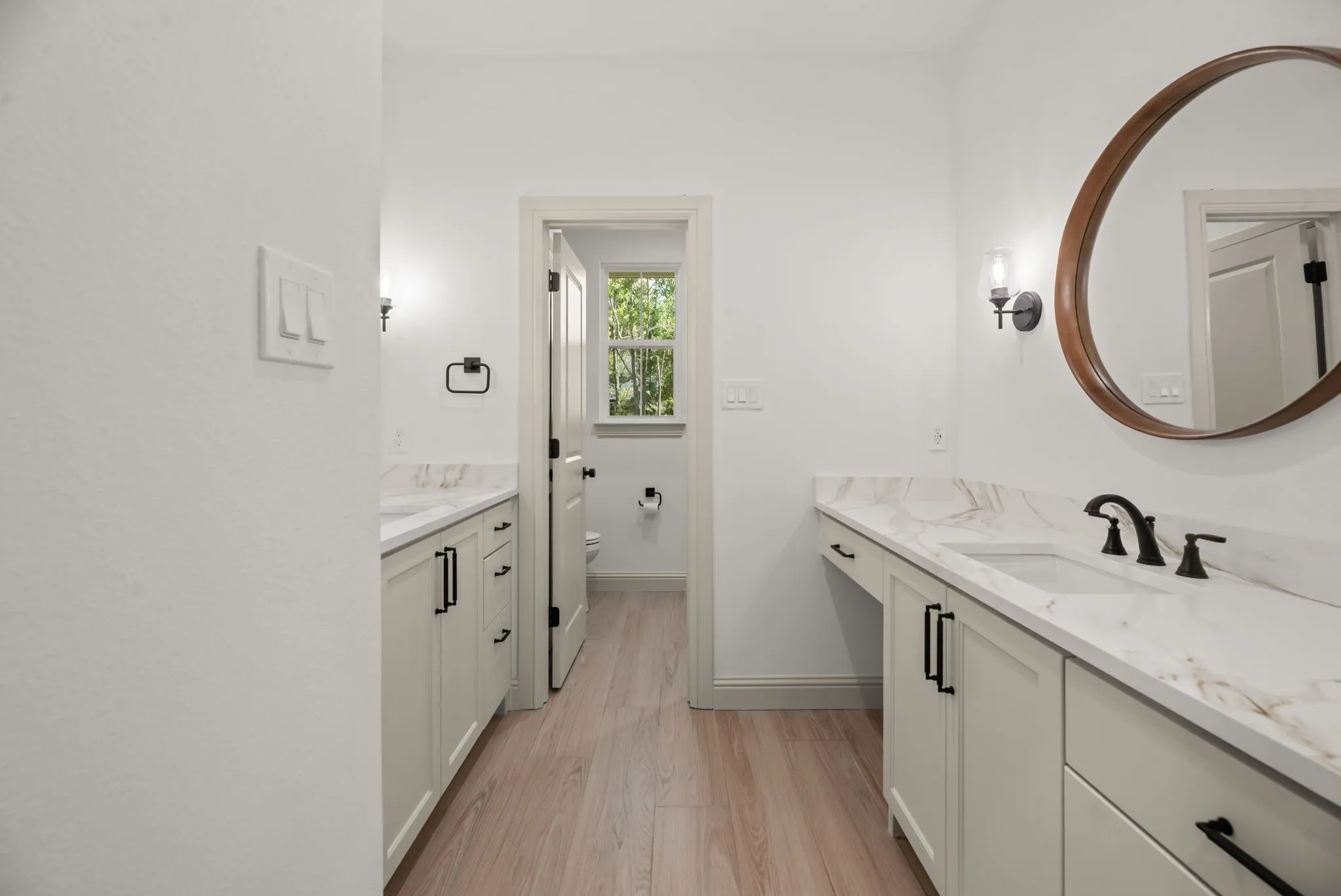 Additional bathroom view highlights generous counter space, custom cabinetry, modern hardware, and a bright functional layout.