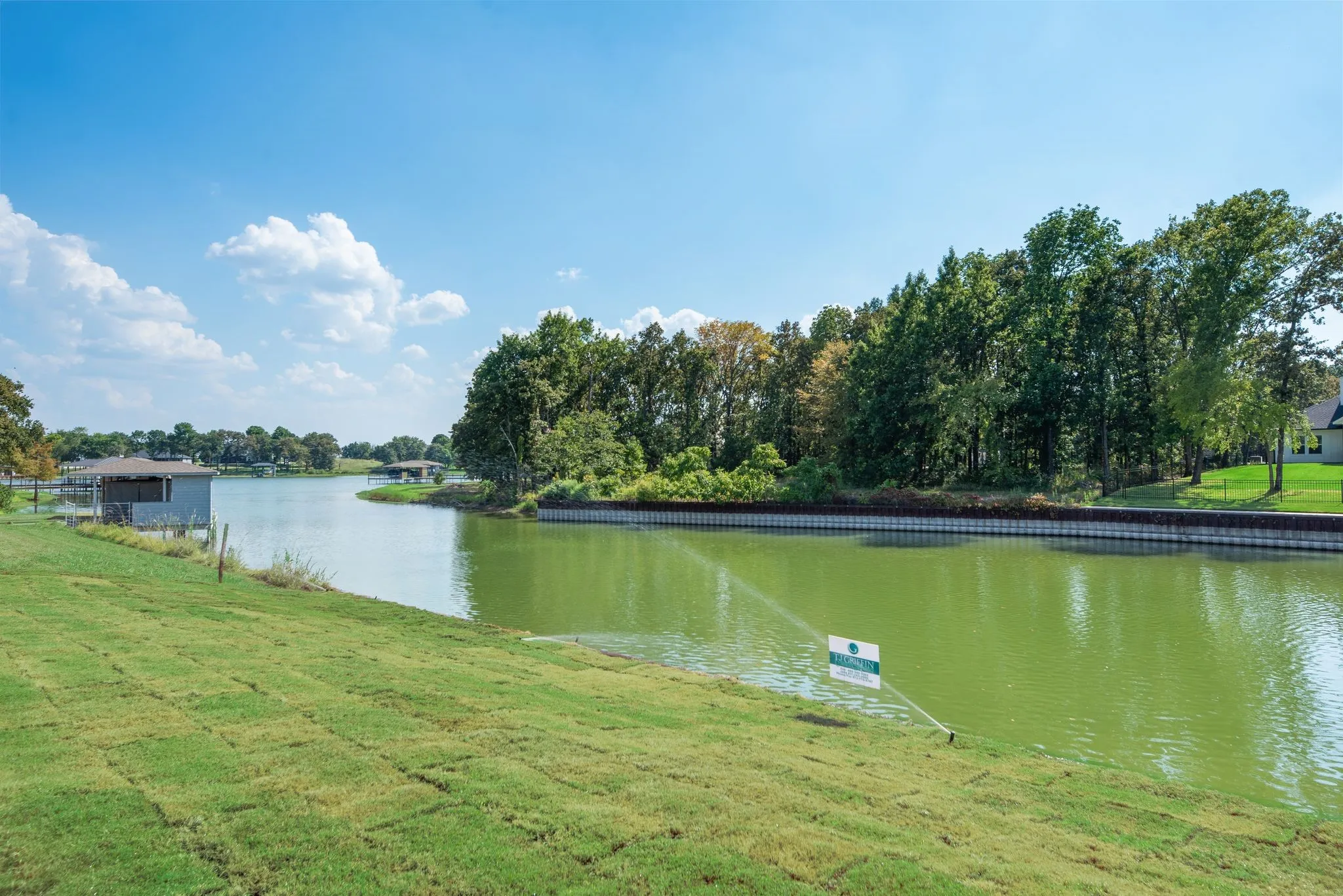 Waterfront property on Richland Chambers Lake features a grassy backyard, steel retaining wall, and shoreline ready for future lakefront enjoyment.