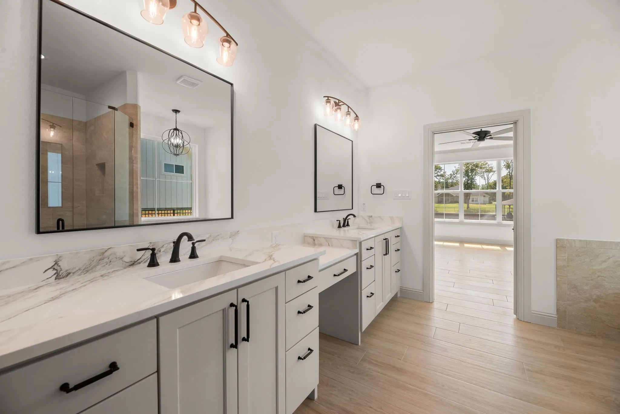Expansive primary vanity provides dual sinks, abundant cabinetry, generous counter space, and a dedicated sit-down vanity area.