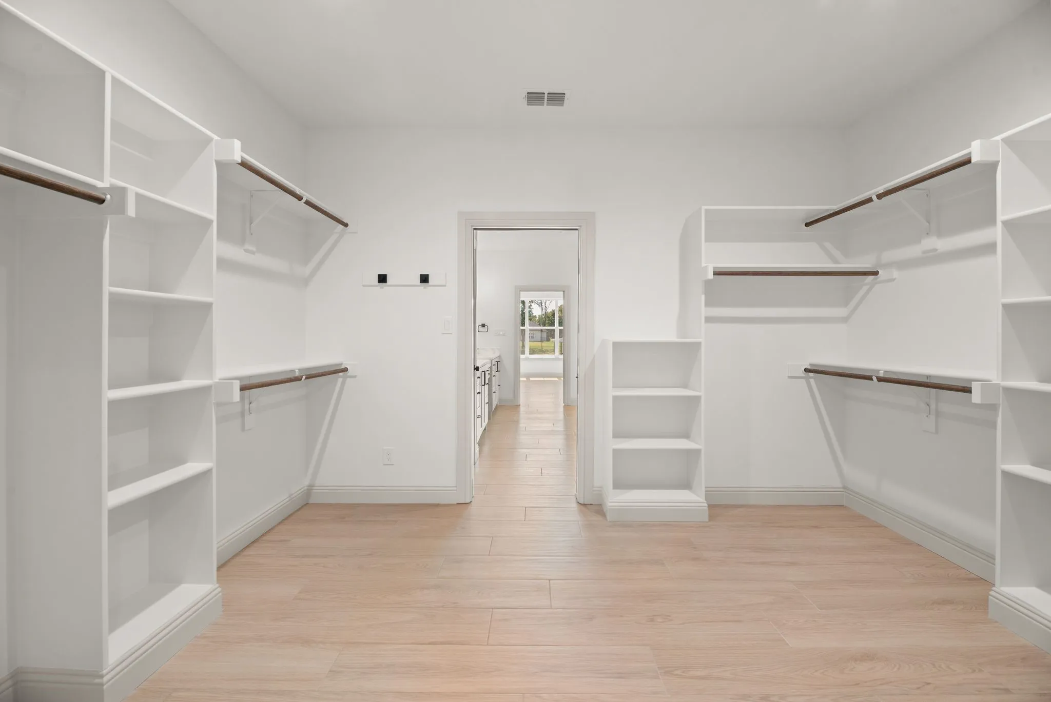 Oversized primary walk-in closet offers extensive shelving and hanging space for exceptional storage in this new Richland Chambers Lake home.