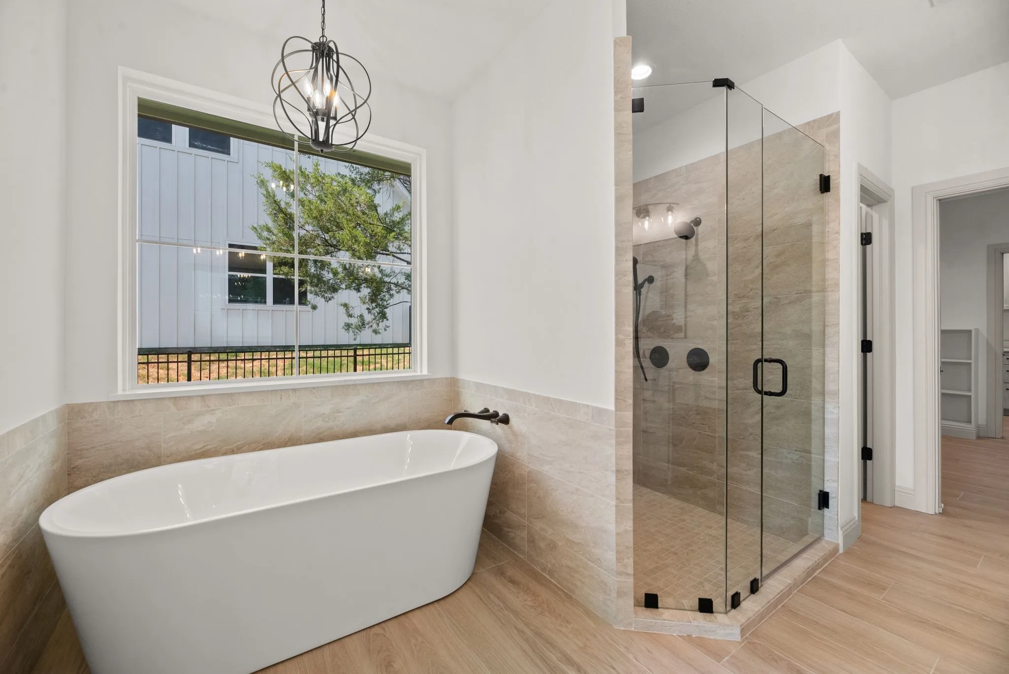 Luxurious primary bath features a freestanding tub and separate glass-enclosed walk-in shower for a relaxing at-home spa experience.