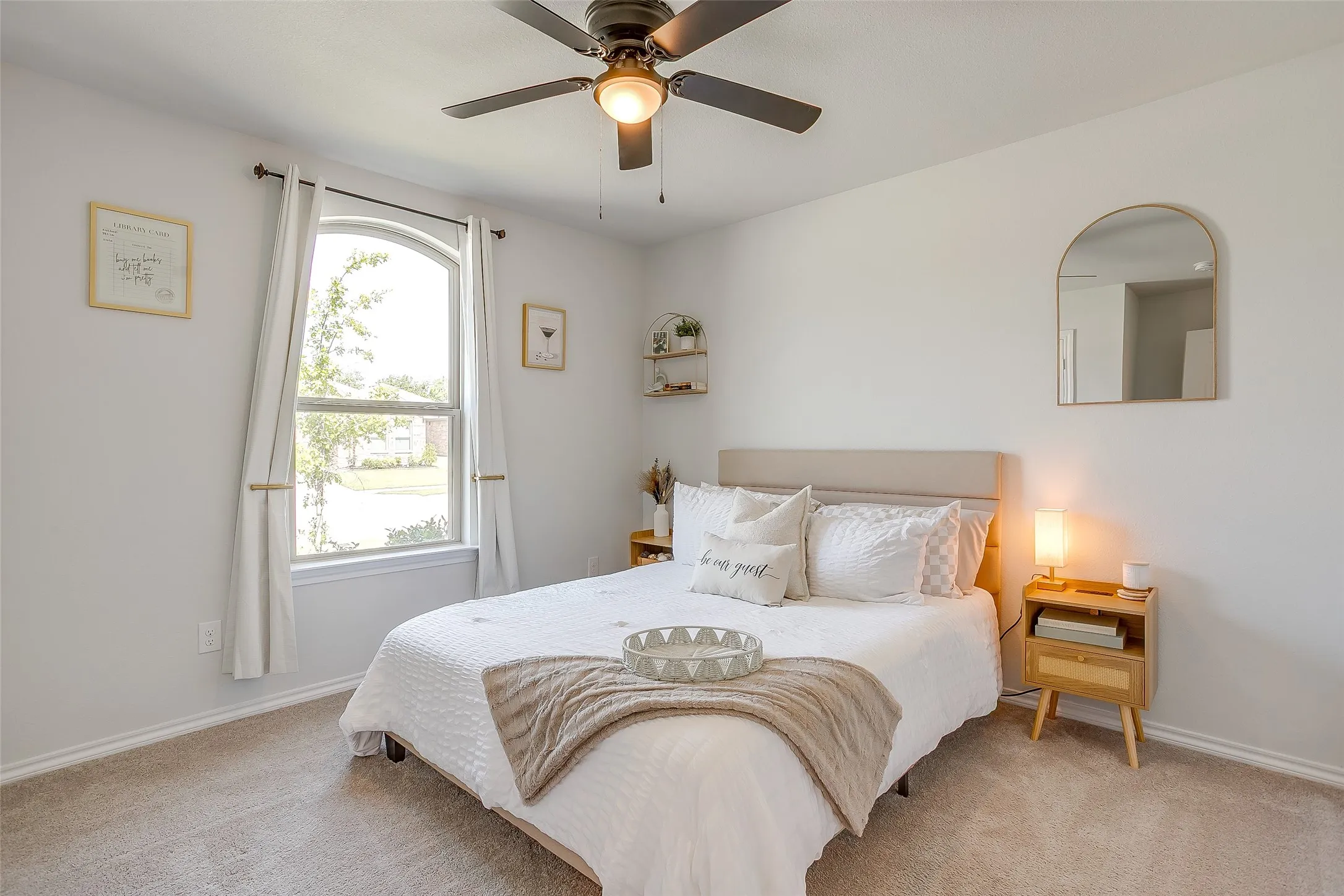 Neutral tone wall paint, arched window, recessed lighting, ceiling fan with integrated lighting, carpeted flooring