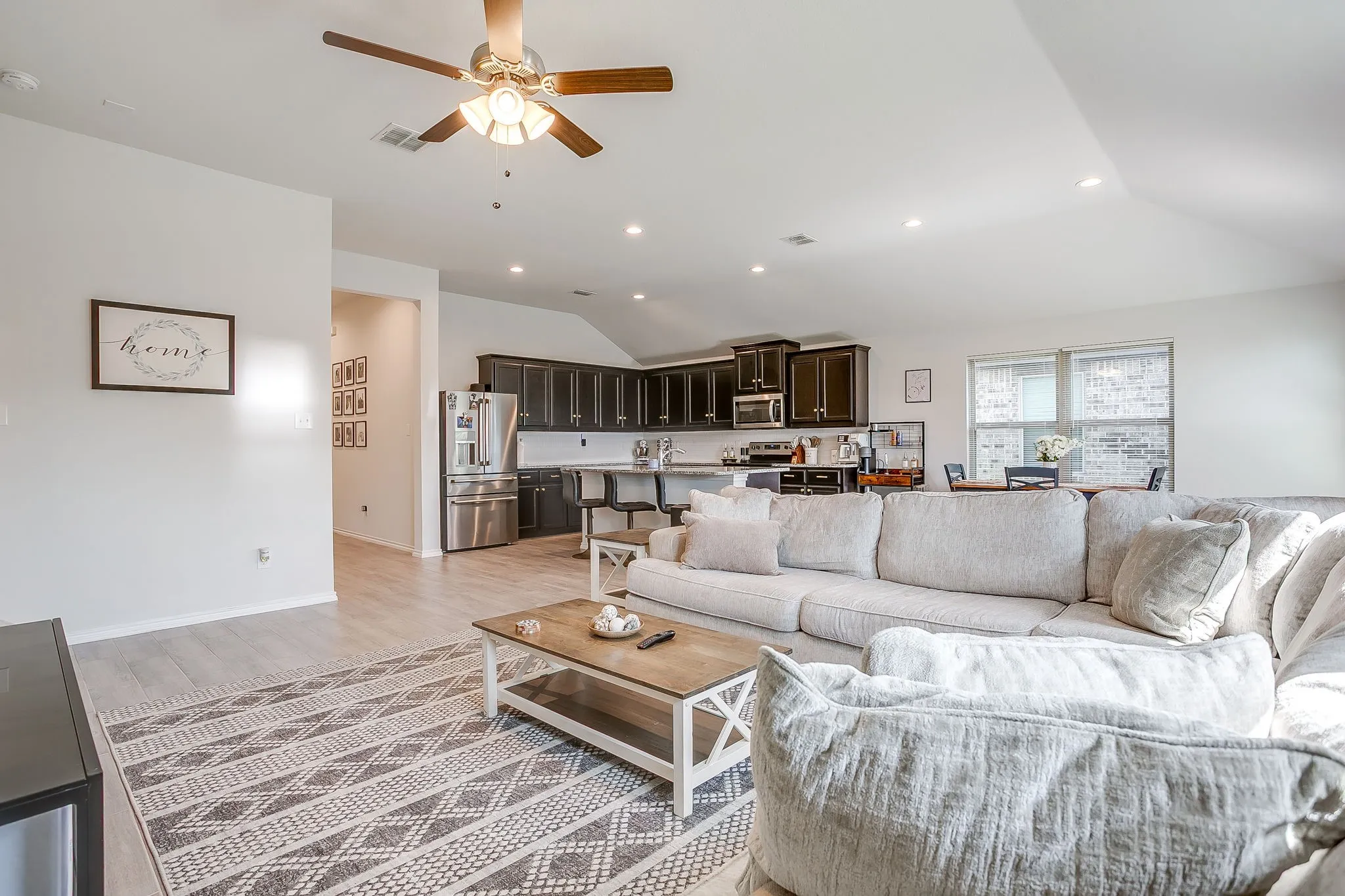 Open-concept living area featuring light wood-finish flooring, recessed lighting, and a ceiling fan