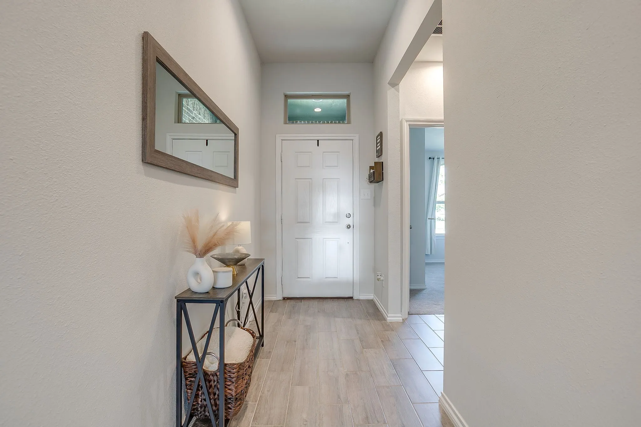 Entryway featuring a panel door, transom window, and wood-finish flooring