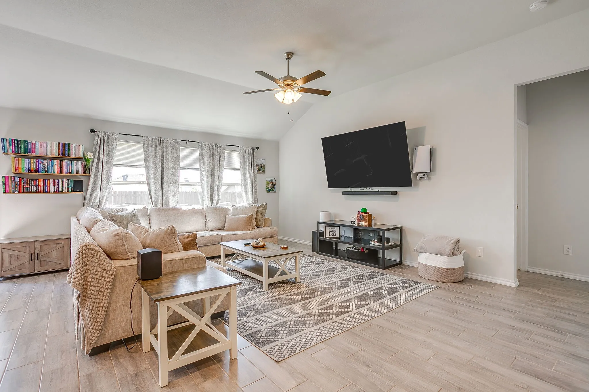 Vaulted ceiling, ceiling fan, wood-finish flooring, multiple windows, built-in shelving