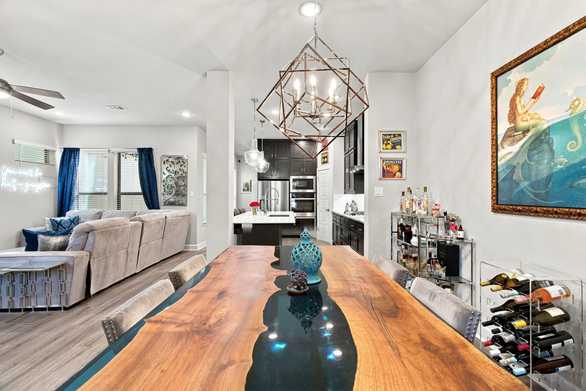 Vaulted ceilings, wood-finish flooring, geometric chandelier, recessed lighting, and kitchen with dark cabinetry