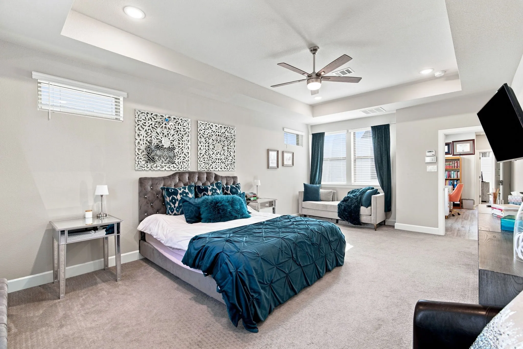 Recessed lighting, ceiling fan, tray ceiling, carpet flooring, and multiple windows