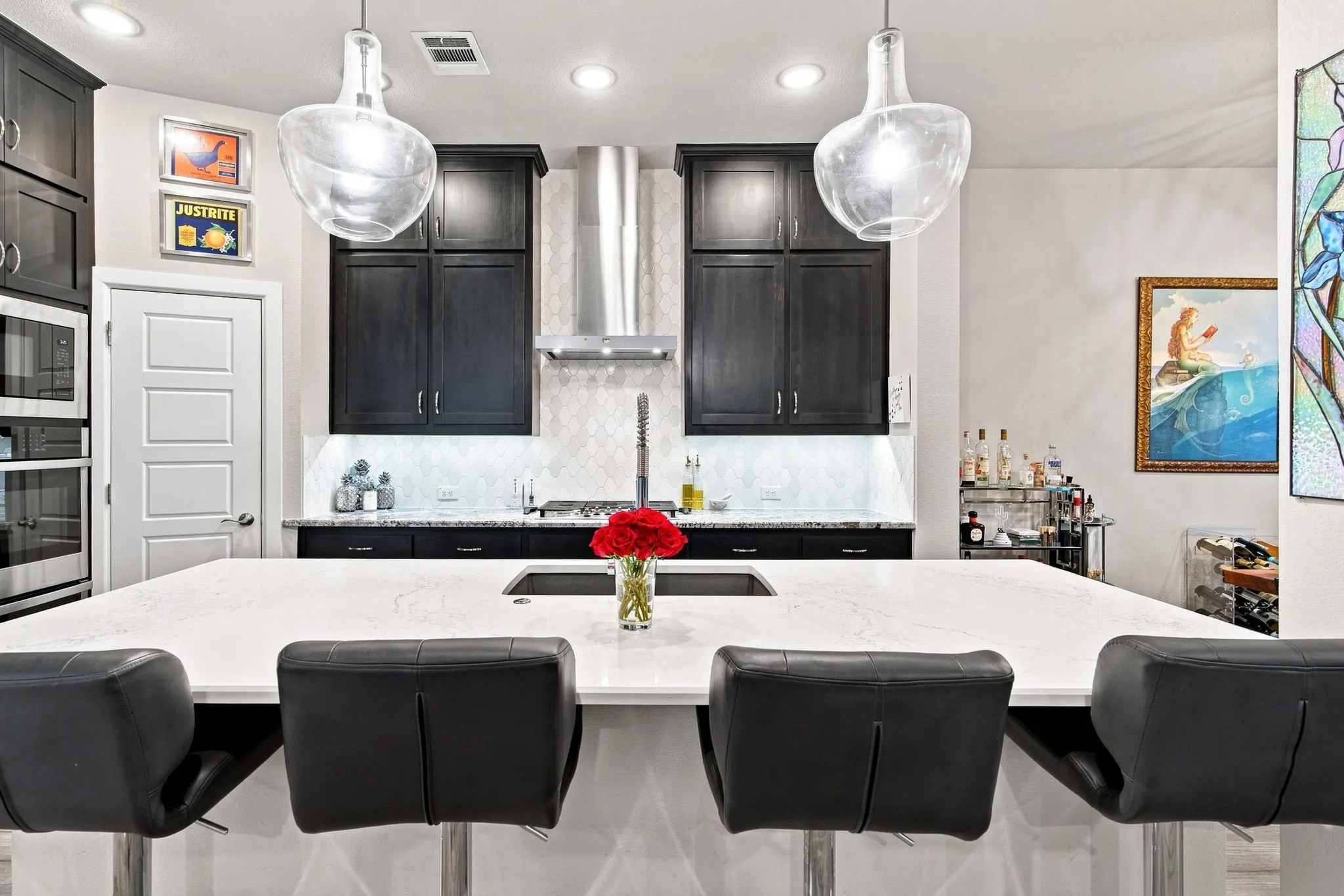 Kitchen featuring a large central island, dark wood-finish cabinetry, stainless steel appliances, and pendant lighting