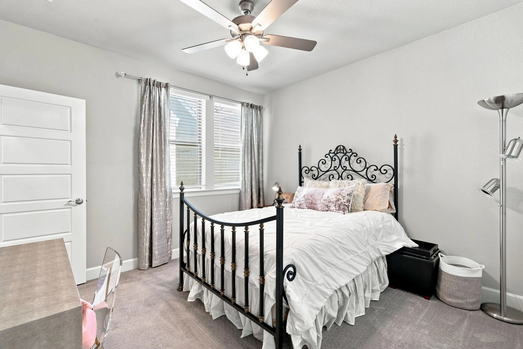 Carpeted flooring complemented by a ceiling fan with integrated lighting