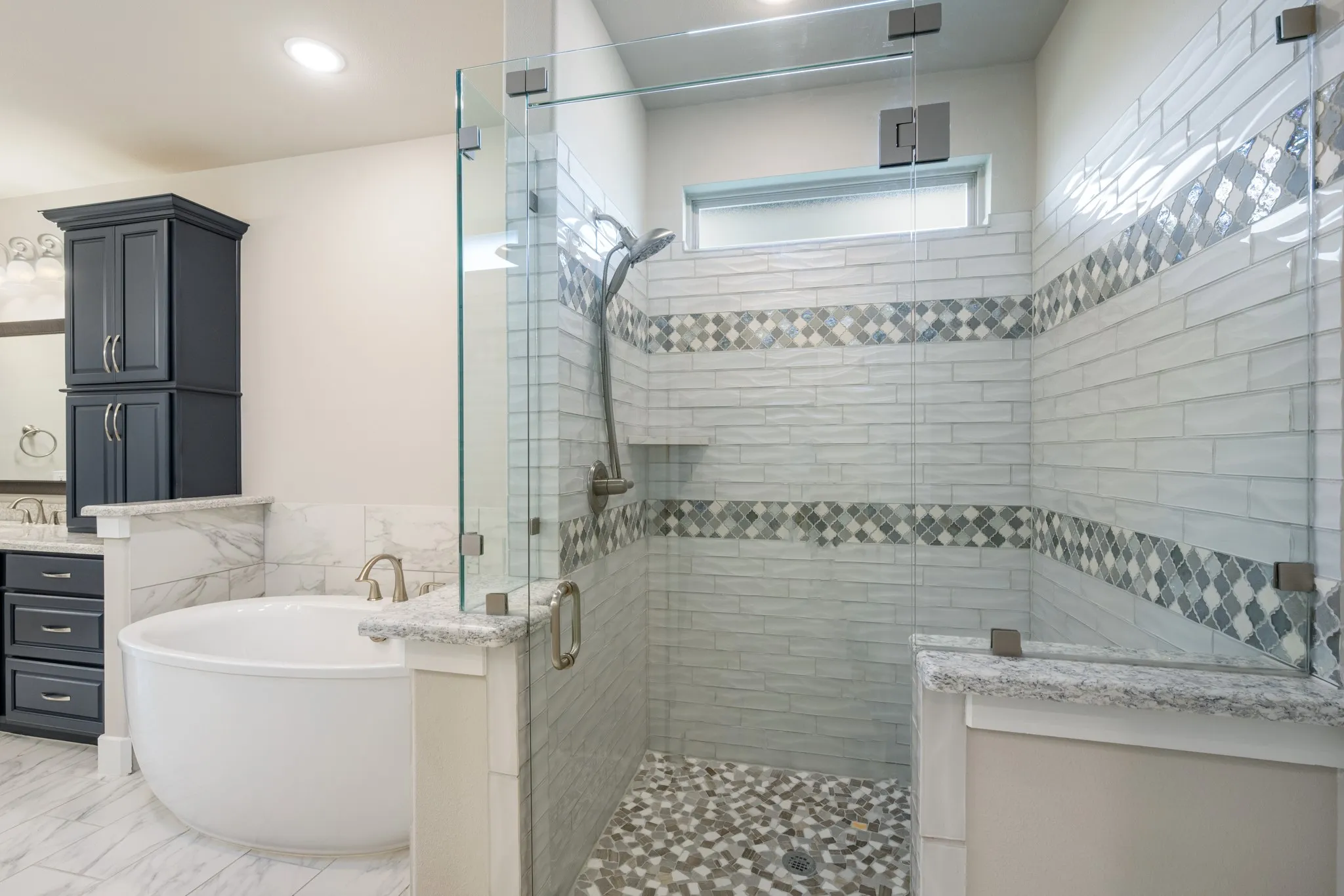 Primary bathroom walk in shower is beautifully tiled.