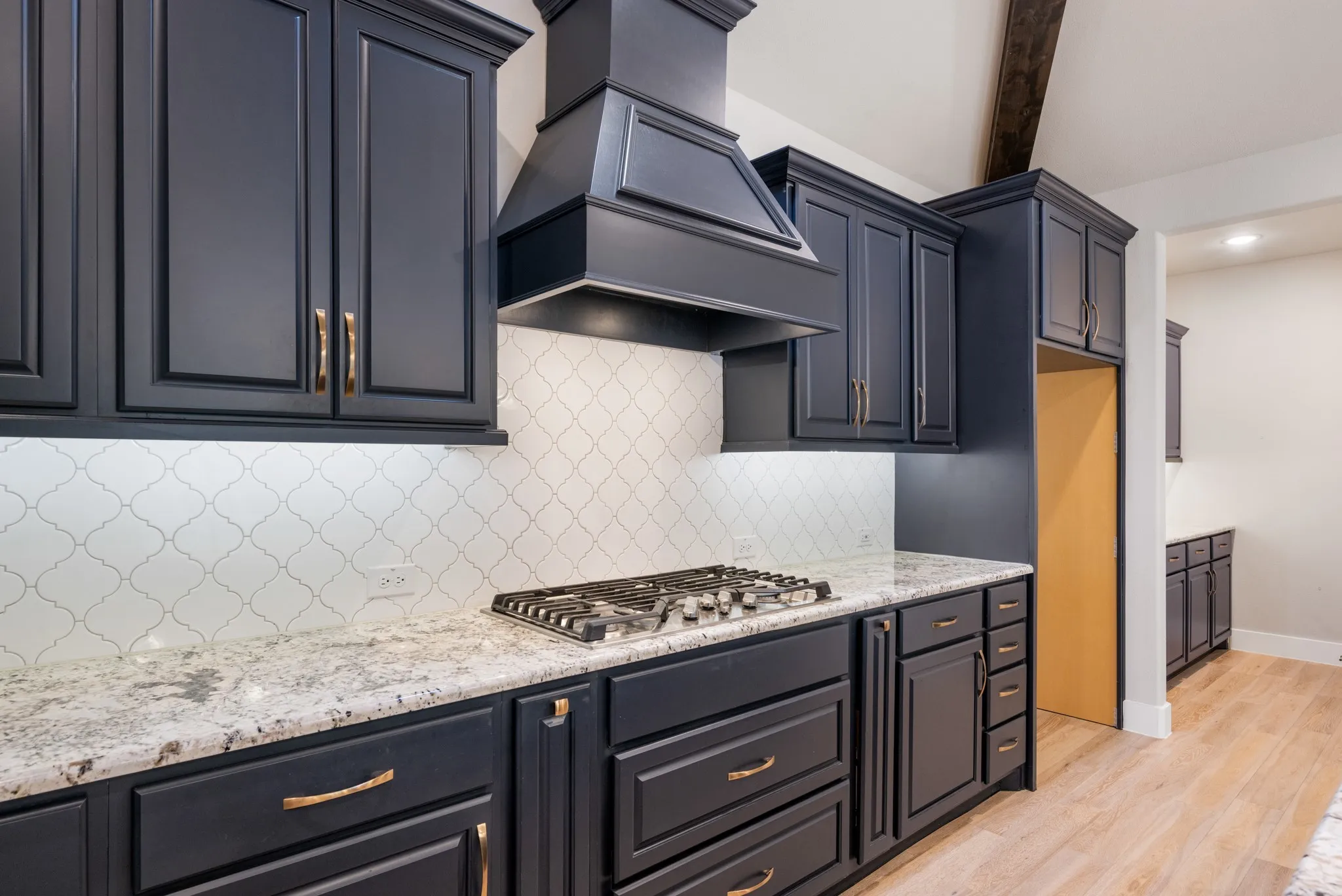 Kitchen features 5 burner a gas cook top.  Backsplash compliments the cabinets perfectly.