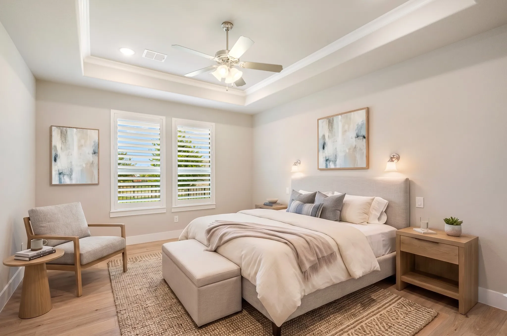 Light and bright primary bedroom with tray ceiling.