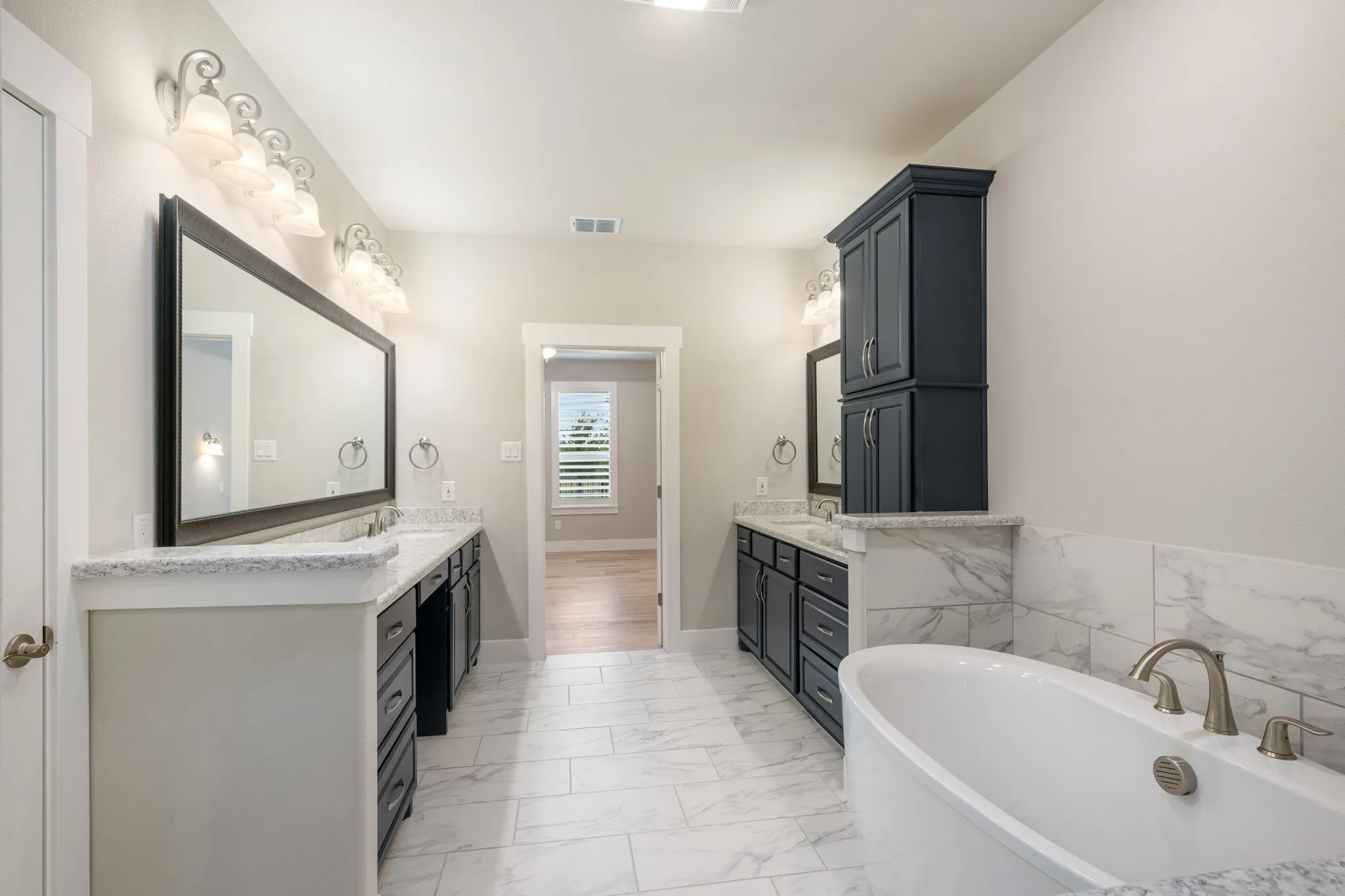 Primary bathroom has double vanities and plenty of storage.