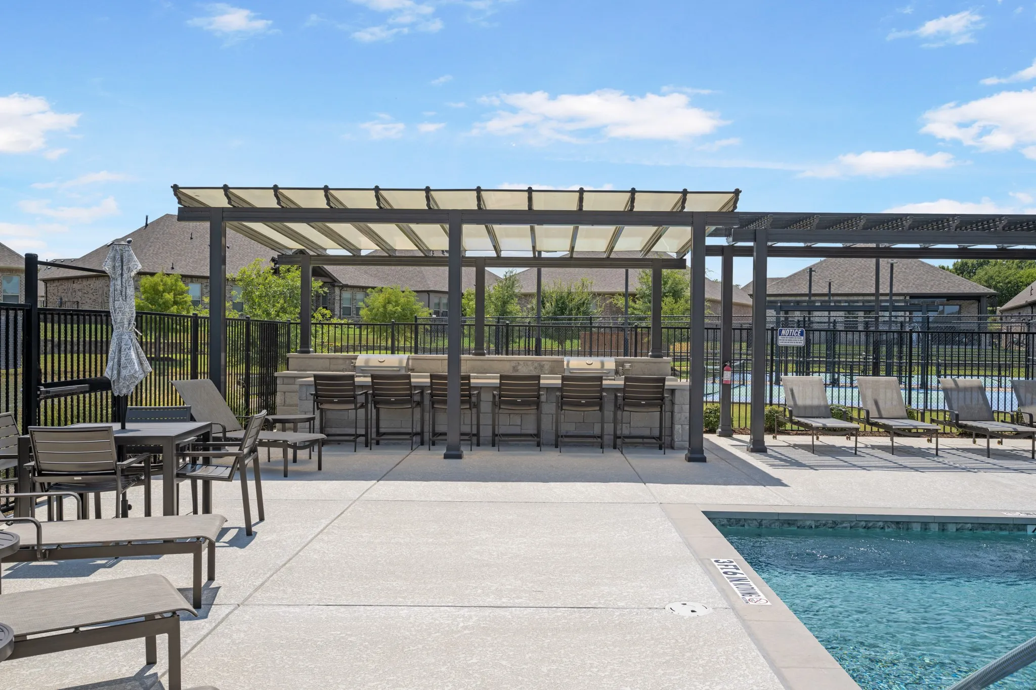 Community pool area features grills and plenty of seating.
