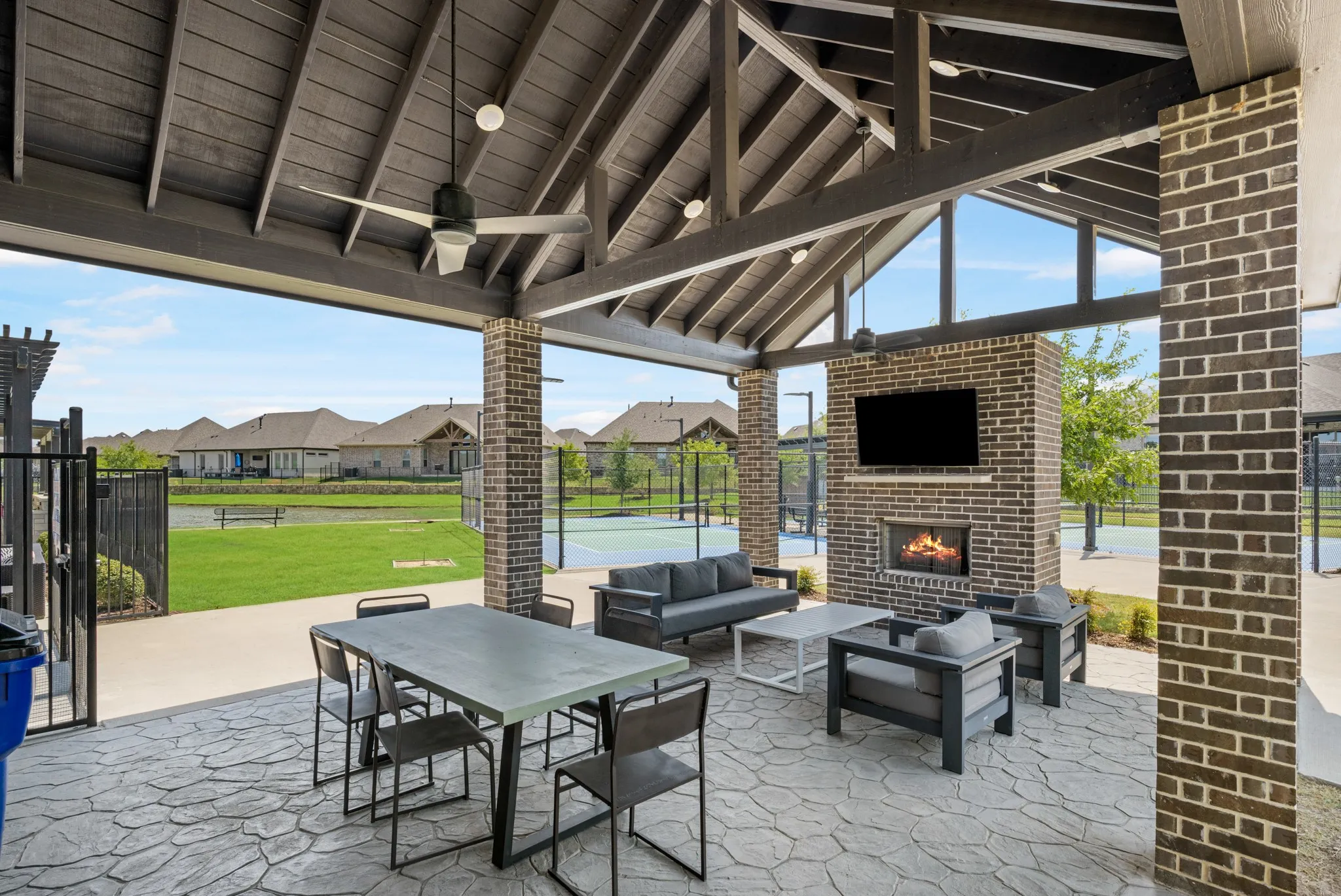 Covered patio area with tv and fireplace in community area.