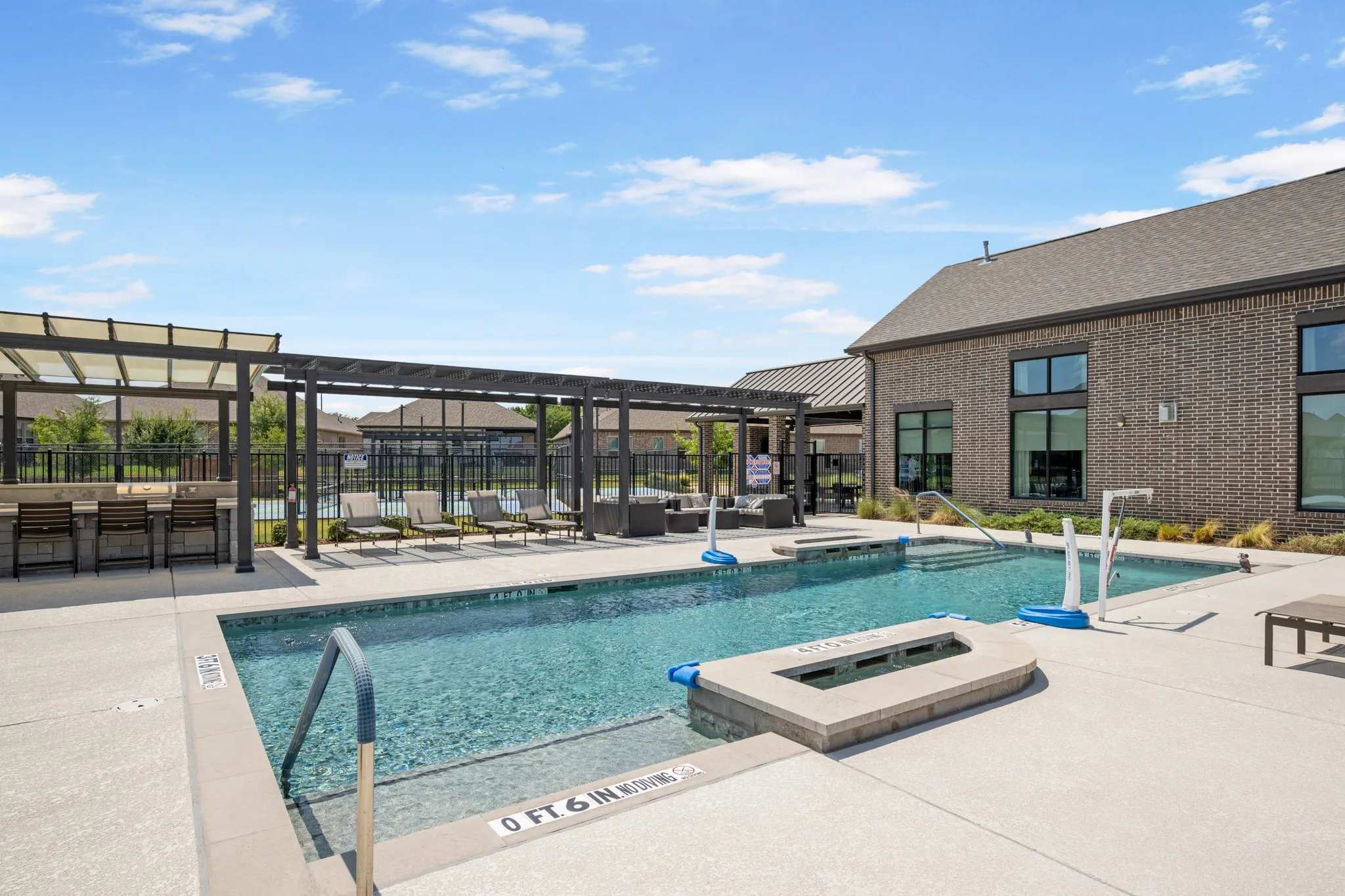 Resort-style community pool featuring a sparkling swimming pool, spacious sun deck, covered outdoor seating areas, and multiple lounge areas. A wonderful amenity for relaxing, entertaining, and enjoying the outdoors.