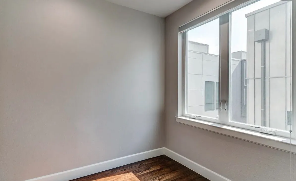 Recessed lighting with a smooth ceiling, wood-finish flooring, and a large window with roller shades
