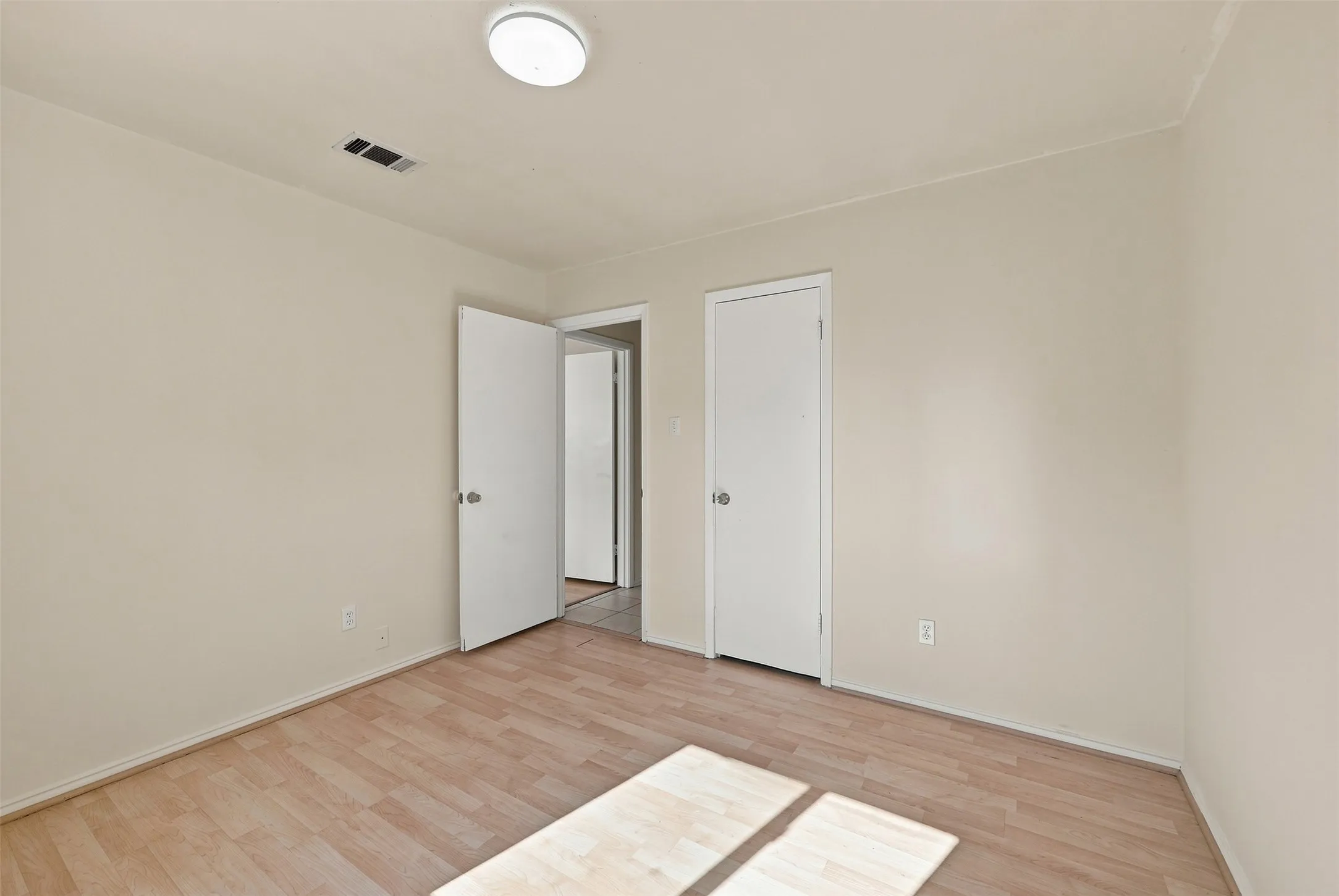 Light-toned walls, wood-finish flooring, and overhead lighting
