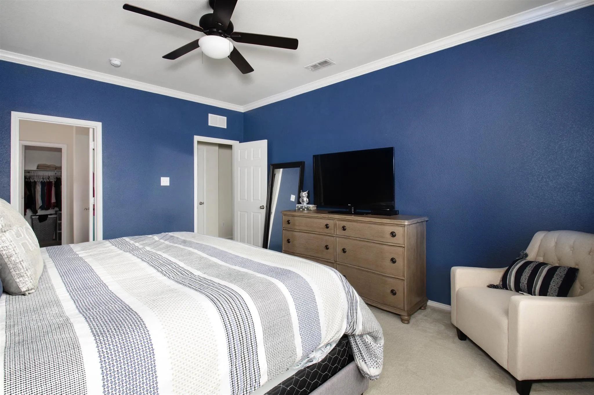 Carpeted flooring, a ceiling fan with integrated lighting, and white crown molding