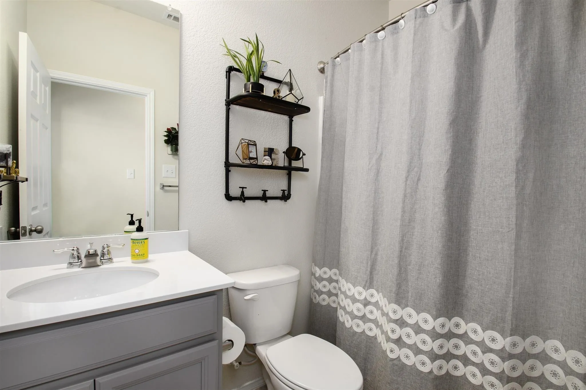 Vanity with white countertop, chrome faucet, and gray cabinetry