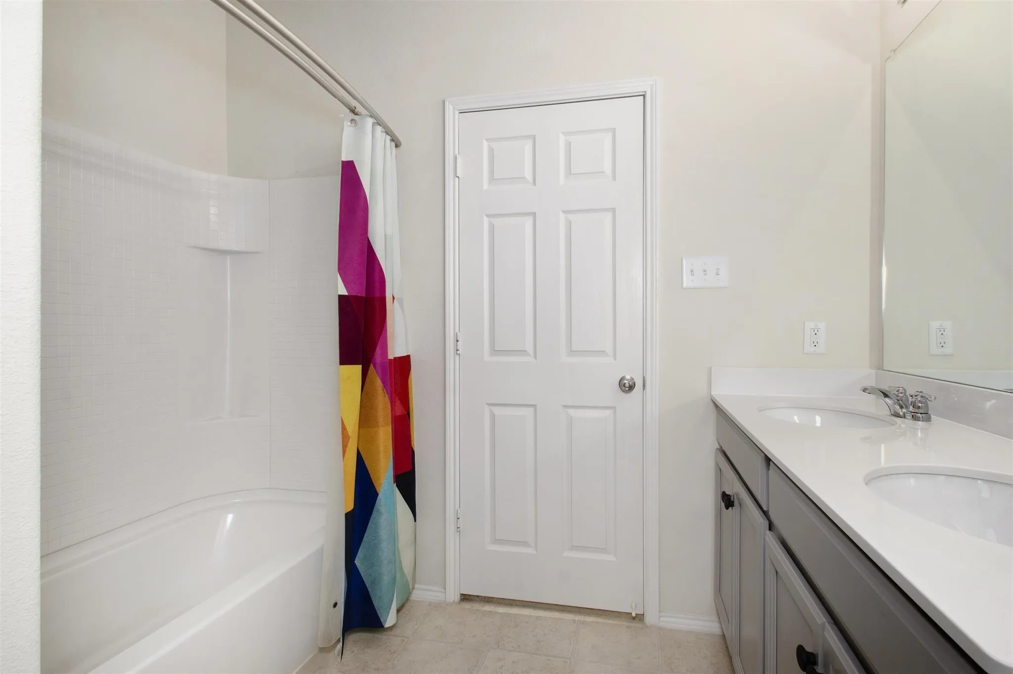 Double vanity with undermount sinks, stone countertop, and chrome fixtures