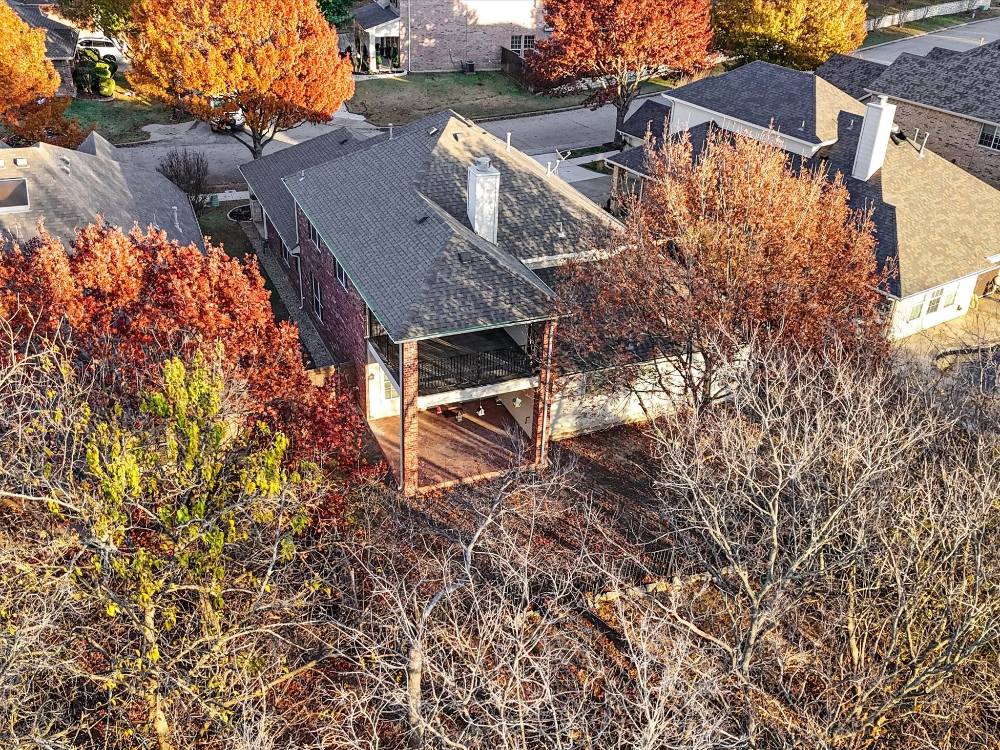 Rear exterior featuring a covered porch, wood-finish decking, and mature landscaping