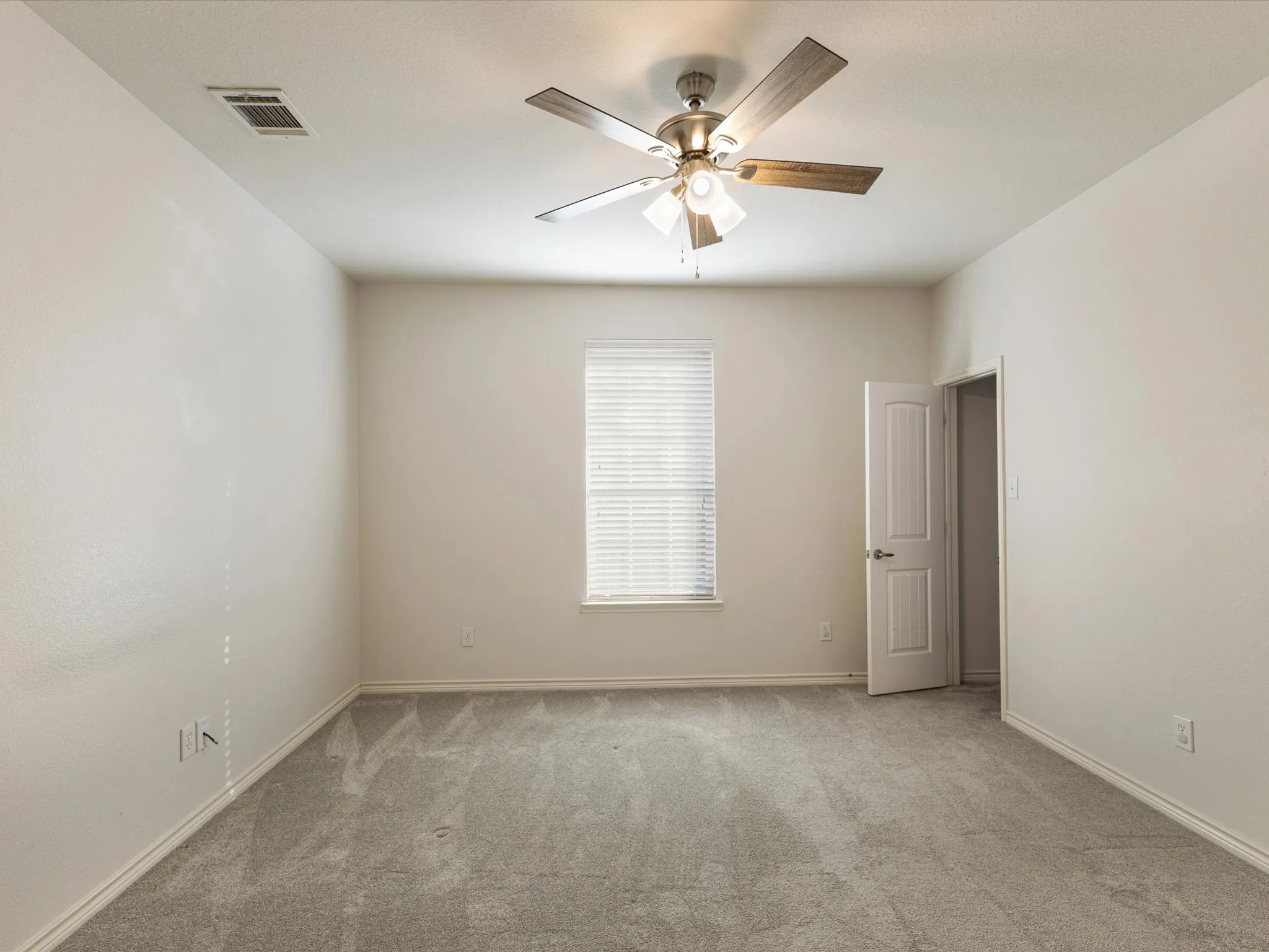 Recessed lighting, ceiling fan with light fixture, window with blinds, light-toned carpeting, and a white interior door