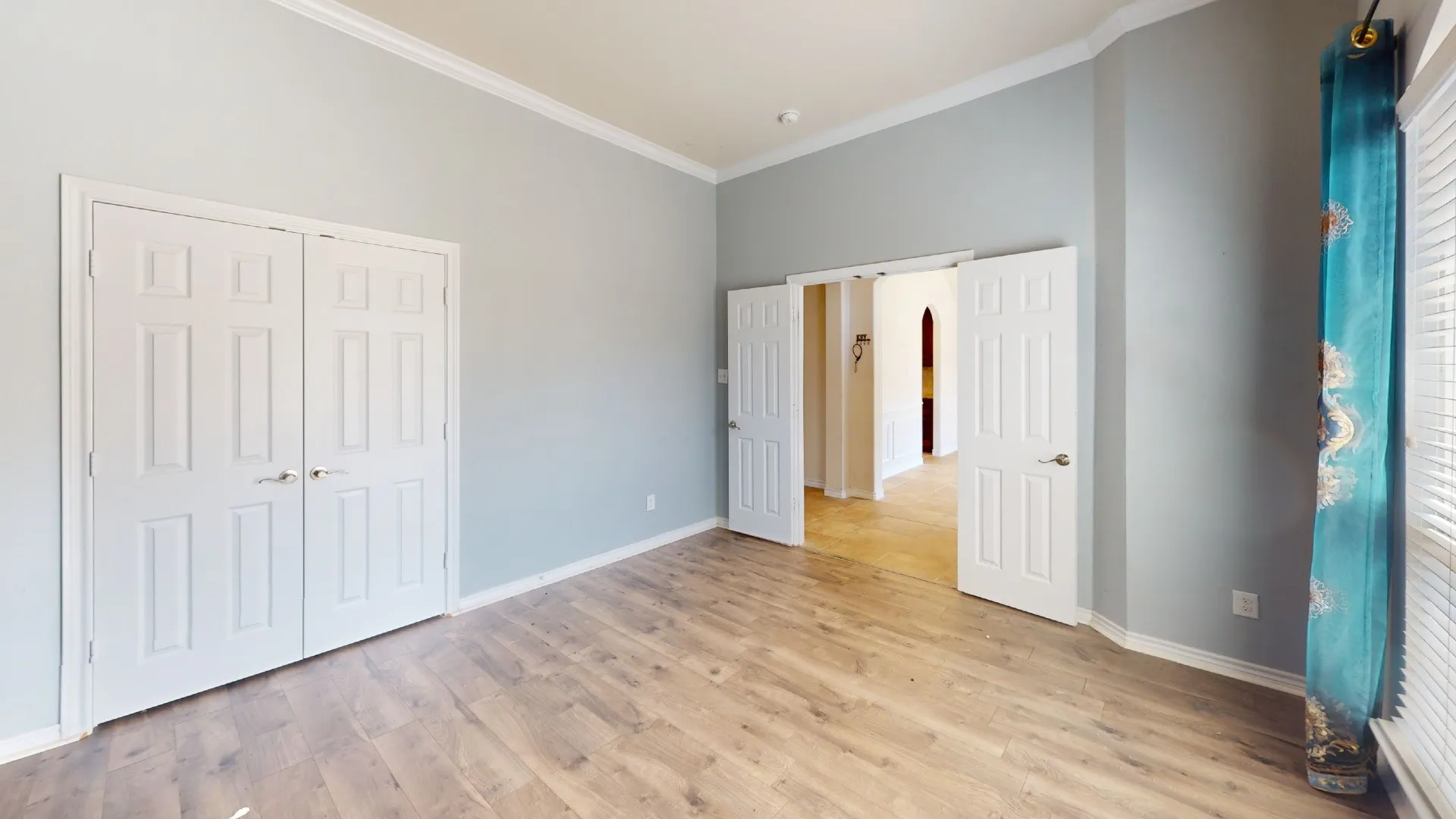 Wood-finish flooring, crown molding, and white trim throughout
