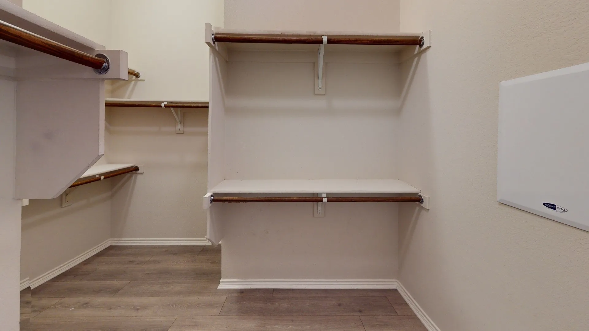 Walk-in closet featuring wood-finish flooring, multiple shelving units, and integrated hanging rods