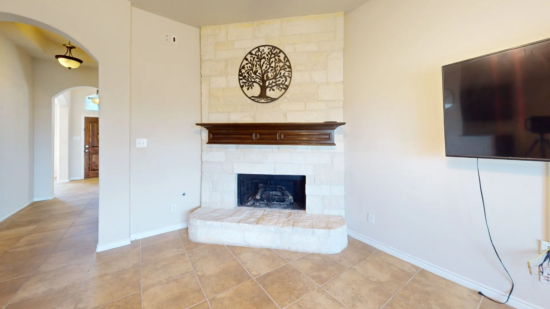 Corner fireplace featuring a stone surround and a dark wood mantel
