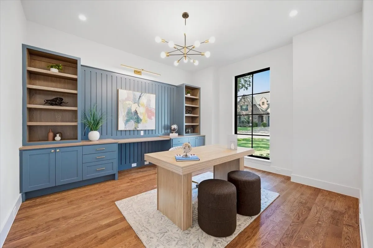 Hardwood-finish flooring, built-in cabinetry, integrated desk space, decorative wall paneling, and an expansive window