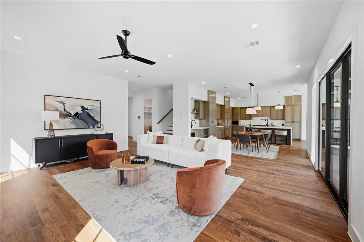 Open-concept living area with wood-finish flooring, recessed lighting, and a modern ceiling fan