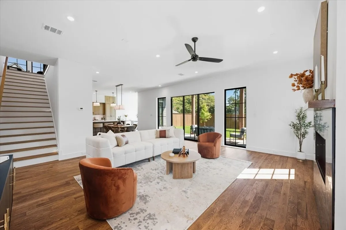 Open-concept living area with wood-finish flooring, a contemporary ceiling fan, and recessed lighting
