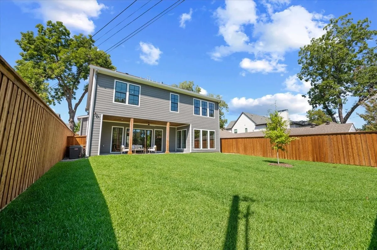 Spacious green lawn with a newly installed wood privacy fence