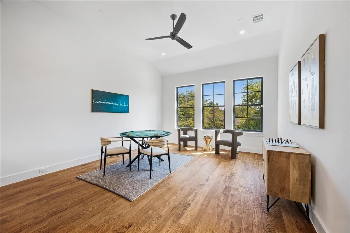 Hardwood flooring, three casement windows, a ceiling fan, recessed lighting, and high ceilings