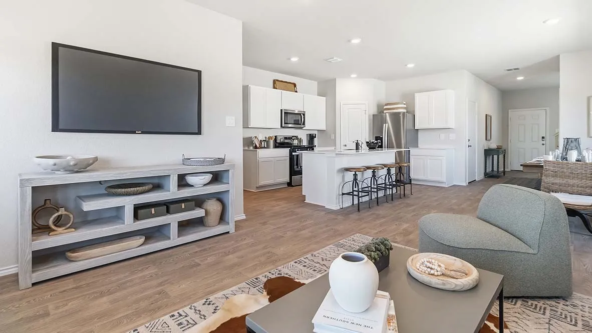 Open concept living area with wood-finish flooring, recessed lighting, white cabinetry, and a kitchen island with seating