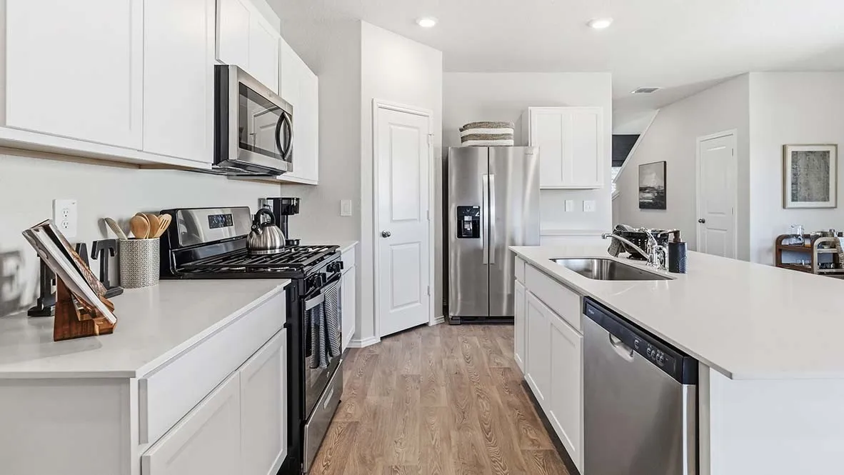 Kitchen featuring white cabinetry, stainless steel appliances, extensive countertop space, wood-finish flooring, and recessed lighting