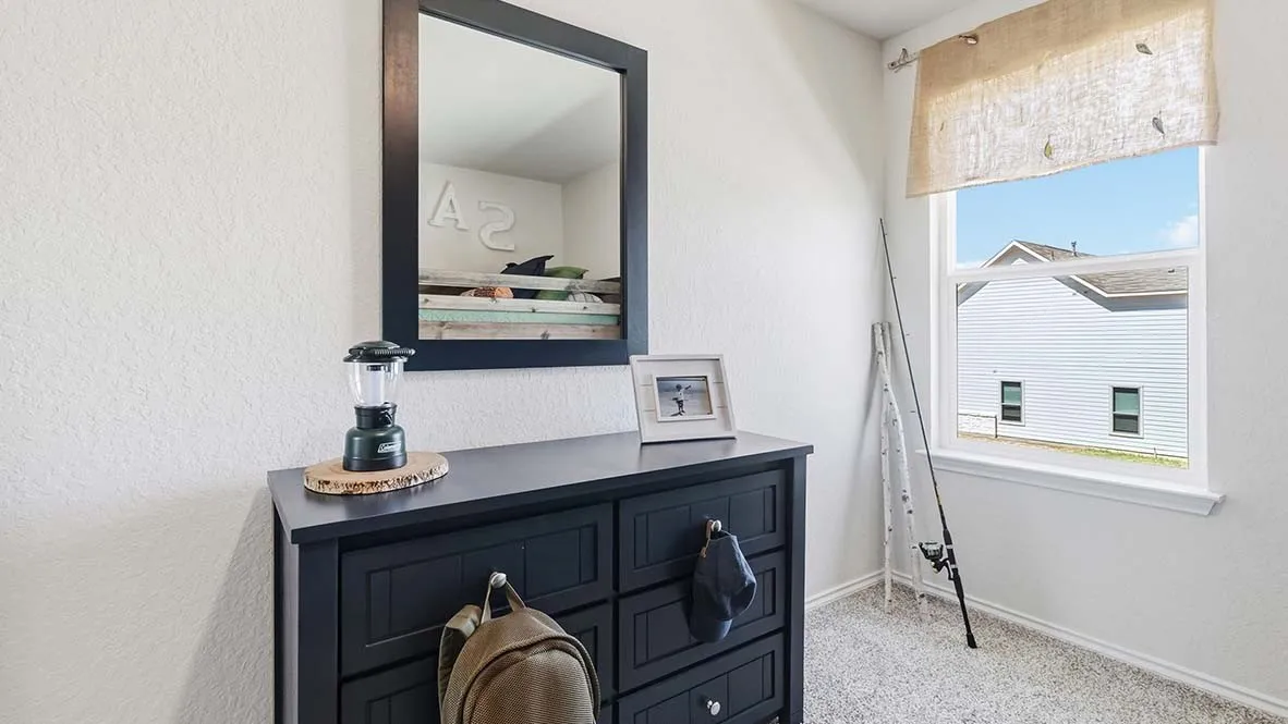 White textured walls with a window featuring a light-colored roller shade