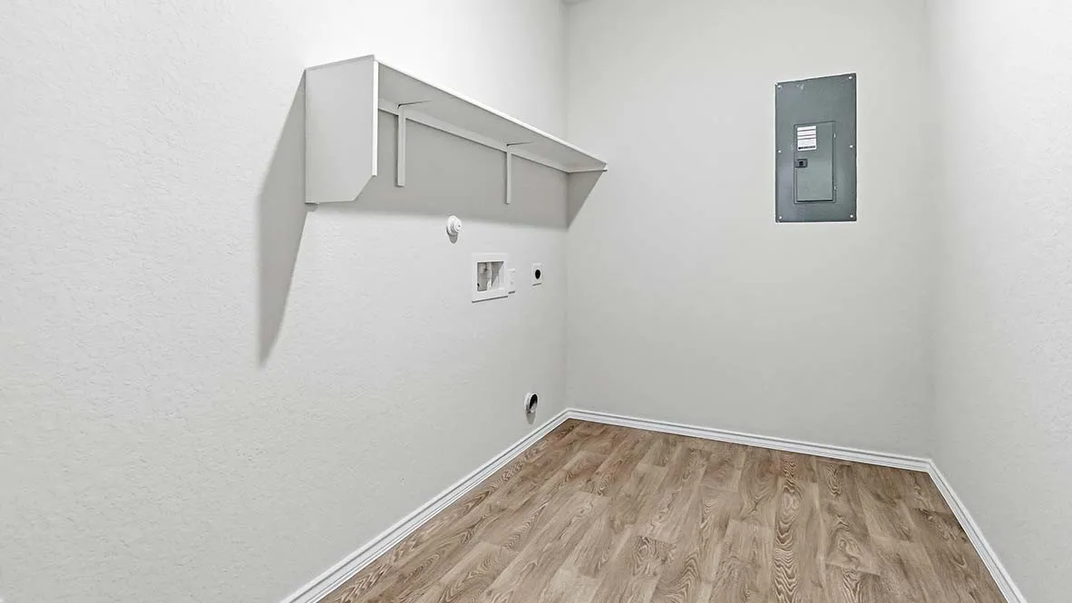 Laundry area featuring wood-finish flooring, white walls, built-in shelving, and utility hookups