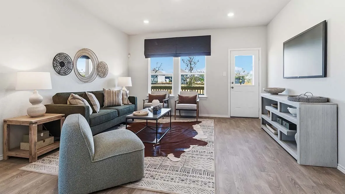 Recessed lighting illuminates the open living area with wood-finish flooring